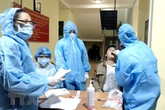 Nhân viên y tế lấy mẫu xét nghiệm cho người dân. (Ảnh: TTXVN phát)