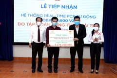 Ông Nguyễn Nam Hiền, Phó Tổng Giám đốc Tập đoàn Hưng Thịnh (thứ 2, từ phải sang) trao tượng trưng hệ thống Real-time PCR tự động cho ông Nguyễn Hồng Tâm, Phó Giám đốc HCDC, Sở Y tế Thành phố Hồ Chí Minh. (Ảnh: Xuân Khu/TTXVN)