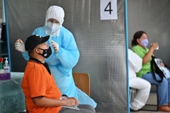 Nhân viên y tế lấy mẫu xét nghiệm COVID-19 tại Bangkok, Thái Lan. (Ảnh: AFP/TTXVN)