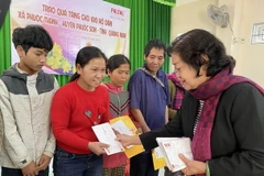 Bà Trương Mỹ Hoa, nguyên Bí thư Trung ương Đảng, nguyên Phó Chủ tịch nước; Chủ tịch Quỹ học bổng Vừ A Dính tặng quà cho người dân bị thiệt hại do bão lũ. (Ảnh: Trần Tĩnh/TTXVN)
