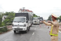 Cảnh sát giao thông kiểm soát phương tiện tại chốt kiểm soát. (Ảnh: Hoàng Hùng/TTXVN)