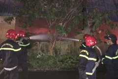 Lực lượng chức năng nỗ lực để đám cháy không lan sang các nhà kho khác liền kề. (Ảnh minh họa: Đỗ Trưởng/TTXVN)