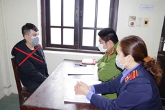 Cơ quan Công an lấy lời khai của đối tượng Đỗ Chính Hợp. (Ảnh: Thanh Tuấn/TTXVN)