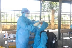 Nhân viên y tế lấy mẫu xét nghiệm cho người dân. (Ảnh: Hoa Mai/TTXVN)