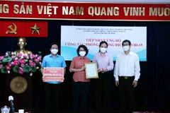 Bà Tô Thị Bích Châu, Chủ tịch Ủy ban MTTQ Việt Nam Thành phố (thứ hai từ trái sang) trao thư cảm ơn Đảng ủy Khối Dân-Chính-Đảng Thành phố Hồ Chí Minh cho bà Lê Hồng Nga, Phó Bí thư thường trực Đảng ủy Khối. (Ảnh: Xuân Khu/TXVN)