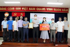 Ông Nguyễn Thành Trung, Phó Chủ tịch Thường trực Ủy ban MTTQ Việt Nam Thành phố trao cho ông Nguyễn Thế Hiệp, Phó Chủ tịch Ủy ban MTTQ Việt Nam tỉnh Thái Bình bức thư cảm ơn. (Ảnh: Xuân Khu/TTXVN)