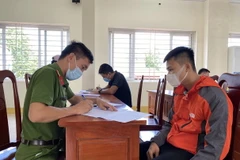 Đối tượng khai báo tại cơ quan chức năng. (Ảnh: Đinh Tuấn/TTXVN)