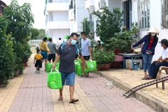 Chuyển nhu yếu phẩm đến cho người dân đang cách ly tại khu C, chung cư Văn Thánh, phường Phú Tài, thành phố Phan Thiết. (Ảnh: Nguyễn Thanh/TTXVN)
