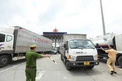 Lực lượng chức năng hướng dẫn các phương tiện quay đầu tại trạm thu phí Pháp Vân-Cầu Giẽ. (Ảnh: Minh Quyết/TTXVN)