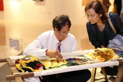 Nghệ nhân Nguyễn Xuân Dục, thôn Bình Lăng, xã Thắng Lợi, huyện Thường Tín, trình diễn tranh thêu tay. (Ảnh: Hoàng Hiếu/TTXVN)