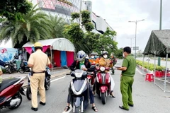 Lực lượng Công an tại chốt kiểm trên đường Phạm Văn Đồng, phường Hiệp Bình Chánh, Thủ Đức, kiểm tra giấy tờ của người lưu thông. (Ảnh: Thành Chung/TTXVN)