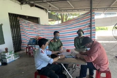 Lực lượng chức năng làm việc với đối tượng liên quan đến hành vi cung cấp, chia sẻ thông tin xúc phạm uy tín cơ quan, tổ chức. (Ảnh: Phan Quân/TTXVN)