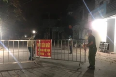 Lực lượng chức năng dỡ bỏ chốt kiểm soát dịch COVID-19. (Ảnh: Thái Hùng/TTXVN)