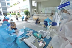 Nhân viên y tế lấy mẫu cho người dân phường Yên Hòa (quận Cầu Giấy). (Ảnh: Minh Quyết/TTXVN)