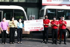 Tiếp nhận tượng trưng 10 xe ôtô chuyên dụng do đại diện Tập đoàn BRG và Ngân hàng SeABank trao tặng. (Ảnh: Xuân Khu/TTXVN)