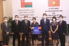 Thứ trưởng Ngoại giao Phạm Quang Hiệu và đại diện ủy ban Trung ương MTTQ Việt Nam tiếp nhận viện trợ. (Ảnh: Lâm Khánh/TTXVN)