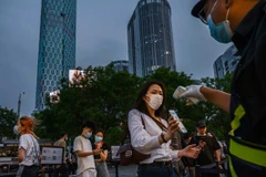 Một người dân Trung Quốc giơ mã QR sức khỏe của mình cho nhân viên bảo vệ quét mã trước khi vào khu vực mua sắm tại Bắc Kinh. (Nguồn: Getty Images)