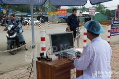 Máy đo thân nhiệt đảm bảo tránh việc tiếp xúc gần. (Nguồn: Báo Nghệ An)