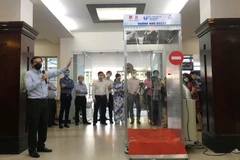 Phó giáo sư, tiến sỹ Nguyễn Tấn Tiến, Giám đốc Phòng thí nghiệm trọng điểm quốc gia điều kiển số và kỹ thuật hệ thống trường Đại học Bách Khoa Thành phố Hồ Chí Minh giới thiệu buồng khử khuẩn. (Ảnh: Thanh Vũ/TTXVN) 