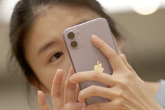 Một người tiêu dùng Trung Quốc sử dụng iPhone 11. (Nguồn: Reuters)