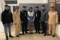 Đối tượng Phạm Ngọc Tuấn (giữa) bị công an bắt giữ. (Nguồn: TTXVN phát)