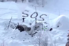 Tyson Steele vẫy tay bên cạnh dòng chữ SOS khi máy bay trực thăng của cảnh sát xuất hiện ở kh vực anh ở. (Nguồn: CNN)