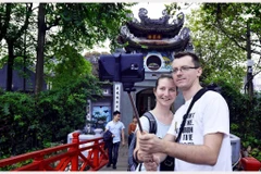 Khách du lịch quốc tế tham quan, chụp ảnh kỷ niệm tại đền Ngọc Sơn (Hà Nội). (Ảnh: Thanh Hà/TTXVN)