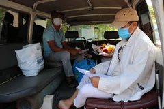 Bệnh nhân nhận và kiểm tra giấy chứng nhận ra viện. (Ảnh: Nguyễn Thành/TTXVN)