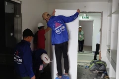 Lực lượng cưỡng chế tháo dỡ các thiết bị tại tầng 18 tòa nhà vi phạm trật tự xây dựng tại 8B Lê Trực. (Nguồn: TTXVN phát)
