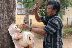 Nghệ nhân ưu tú Ksor Krôh tạc tượng dân gian Tây Nguyên. (Ảnh: Hồng Điệp/TTXVN) 