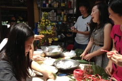 Sinh viên Việt Nam tại Sydney đang gói bánh chưng đón tết. (Nguồn: Đỗ Vân-TTXVN)