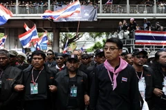  Cảnh sát gác bên ngoài trụ sở chính trong khi người biểu tình chống chính phủ tuần hành tại Bangkok ngày 26/2. (Nguồn: AFP/TTXVN)