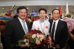 Tổng Cục trưởng Tổng cục Giáo dục nghề nghiệp Nguyễn Hồng Minh tặng hoa cho thí sinh Trương Thế Diệu đạt Huy chương Bạc Kỳ thi tay nghề thế giới lần thứ 45 nghề Phay CNC tại Sân bay quốc tế Nội Bài. (Ảnh: Anh Tuấn/TTXVN)