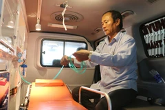 Ông Ngô Văn Đậu đang kiểm tra lại các thiết bị hỗ trợ cấp cứu trên xe chuyển viện do ông và gia đình mua trị giá 700 triệu đồng để vận chuyển bệnh nhân miễn phí. (Ảnh: Công Mạo/TTXVN)