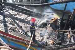 Phun nước dập lửa tàu cá bị cháy. (Ảnh minh họa: TTXVN phát)