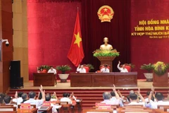 Các đại biểu HĐND tỉnh Hòa Bình biểu quyết thông qua các Nghị quyết tại kỳ họp. (Ảnh: Nhan Sinh/TTXVN)