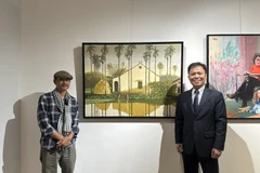 Đại sứ Việt Nam tại Mông Cổ Doãn Khánh Tâm chụp ảnh lưu niệm cùng tác giả bên tác phẩm. (Nguồn: Đại sứ quán Việt Nam tại Mông Cổ)