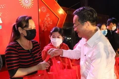 Công nhân, người lao động thị xã Bến Cát, tỉnh Bình Dương nhận quà và lì xì từ các cấp Tổng Liên đoàn lao động và các đơn vị chia sẻ trong những ngày cận Tết. (Ảnh: TTXVN phát)