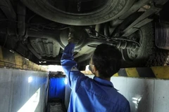 Kiểm định viên kiểm tra gầm bệ phương tiện. (Ảnh minh họa. Nguồn: TTXVN)