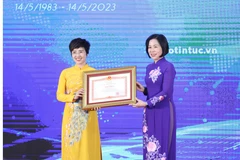 Tổng Giám đốc TTXVN Vũ Việt Trang trao Bằng khen của Thủ tướng Chính phủ cho bà Ninh Hồng Nga, Tổng biên tập Báo Tin tức. (Ảnh: Tuấn Anh/TTXVN)