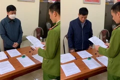 Lực lượng công an tống đạt các quyết định đối với 2 đối tượng Nghiêm Xuân Thông và Lê Văn Diệu. (Ảnh: TTXVN phát)