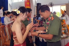 Nghi lễ buộc chỉ tay trong lễ đón Tết cổ truyền Bunpimay (Lào) được tổ chức ở Phân hiệu Đại học Đà Nẵng tại tỉnh Kon Tum. (Ảnh: Khoa Chương/TTXVN)