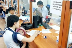 Người dân thực hiện thủ tục hành chính. (Ảnh: PV/Vietnam+)