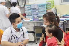 Khám cho trẻ mắc bệnh tay chân miệng. (Ảnh: TTXVN phát)