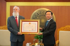 Phó Thủ tướng, Bộ trưởng Bộ Tài nguyên và Môi trường Trần Hồng Hà trao Huy chương Hữu nghị cho tiến sỹ Michael Parsons. (Ảnh: Hoàng Hiếu/TTXVN)
