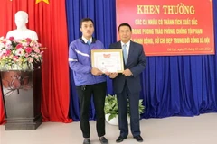 Chủ tịch Ủy ban Nhân dân thành phố Đà Lạt Tôn Thiện San tặng giấy khen cho tài xế taxi Nguyễn Duy Phin. (Ảnh: Quốc Hùng/TTXVN)