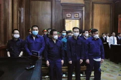 13 cựu cán bộ Công an phường Phú Thọ Hòa tại tòa. (Ảnh: Thành Chung/TTXVN)