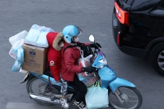 Dễ dàng bắt gặp chiếc xe máy chở cồng kềnh đồ đạc trên đường. (Ảnh: Hoàng Hiếu/TTXVN)