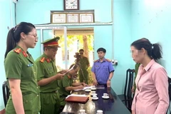 Cơ quan công an đọc quyết định khởi tố đối với đối tượng Đ.T.T. (Ảnh: TTXVN phát)