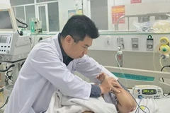 Bác sỹ Bệnh viện Nhi đồng 2, Thành phố Hồ Chí Minh điều trị tích cực cho một học sinh trong vụ tai nạn. (Ảnh: TTXVN phát)